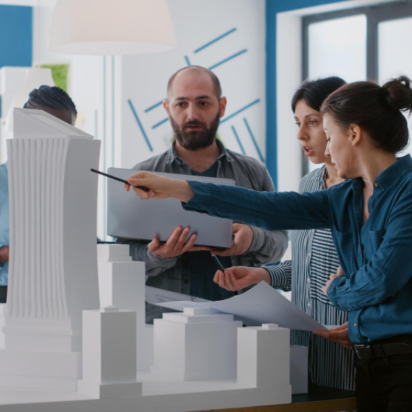 Professionnels analysant une maquette de projet immobilier commercial lors d’une réunion stratégique